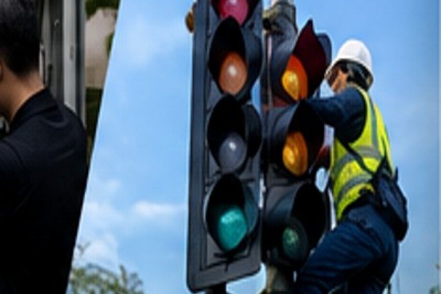 Technician maintaining traffic light equipment